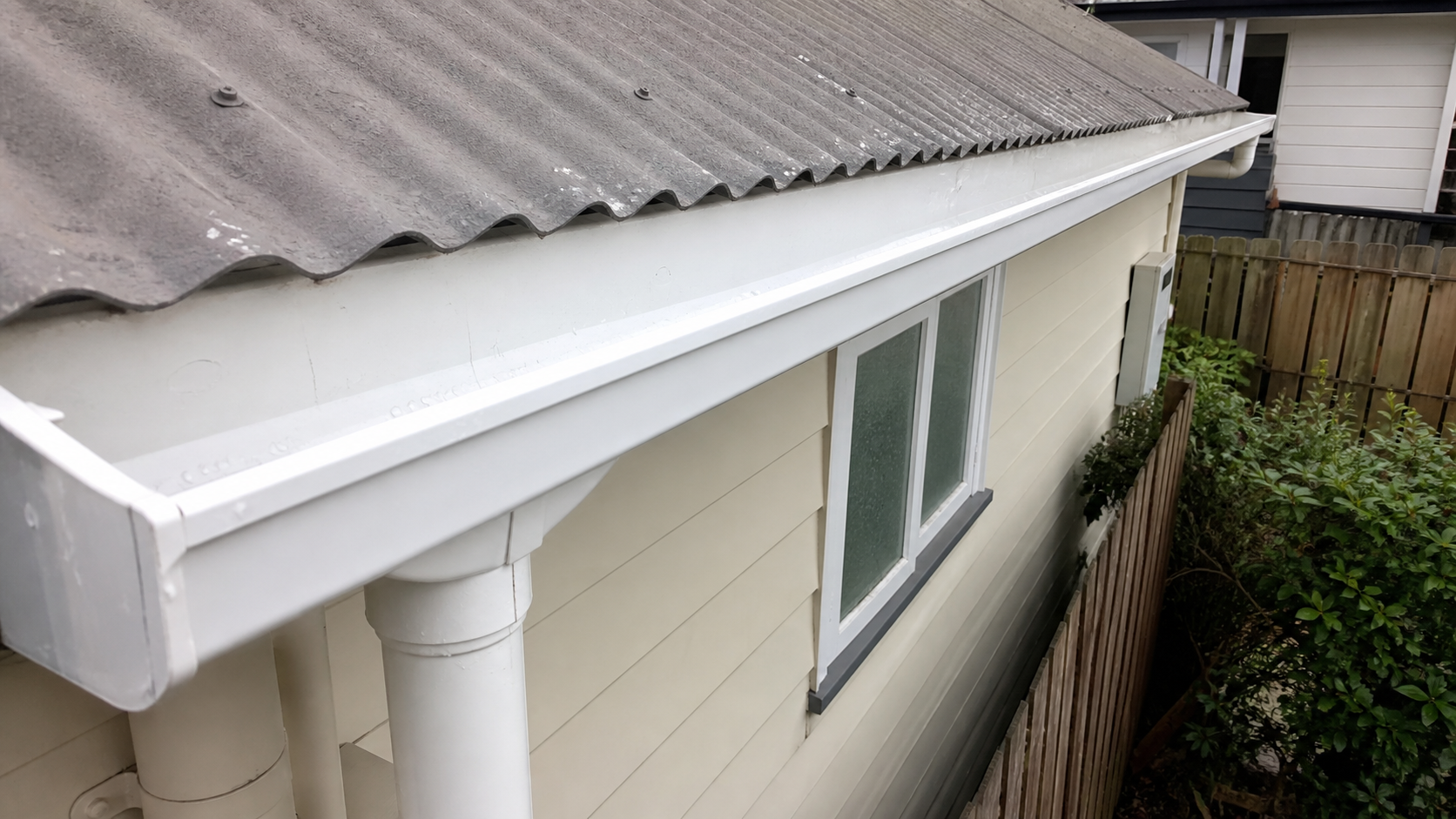Freshly cleaned white gutter on a Hamilton weatherboard home