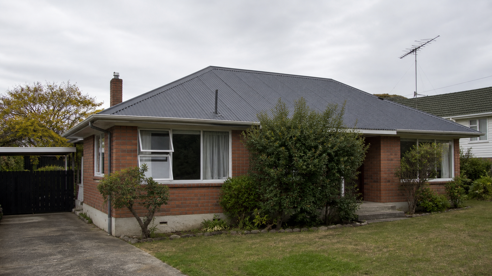 Newly painted charcoal corrugated roof on a Hamilton brick bungalow